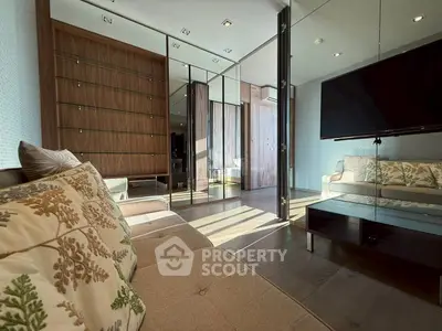Spacious modern living room with elegant decor and large TV, perfect for relaxation and entertainment.