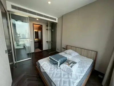 Modern bedroom with city view and sleek design, featuring a comfortable bed and ample storage space.