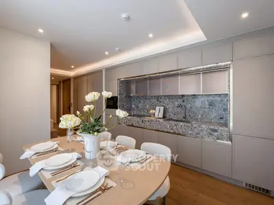 Elegant modern kitchen with open layout and stylish dining area, featuring sleek cabinetry and contemporary decor.
