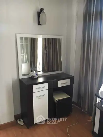 Stylish bedroom vanity with mirror and modern lighting in a cozy room.