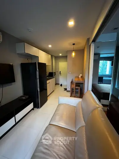 Modern apartment interior with open layout, featuring sleek kitchen and cozy living area.