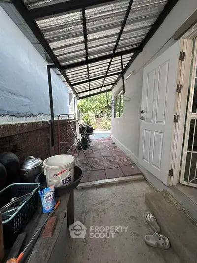 Charming covered patio with garden view and practical storage space.