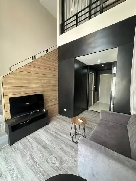 Modern living room with loft design, featuring sleek furniture and stylish wooden accents.