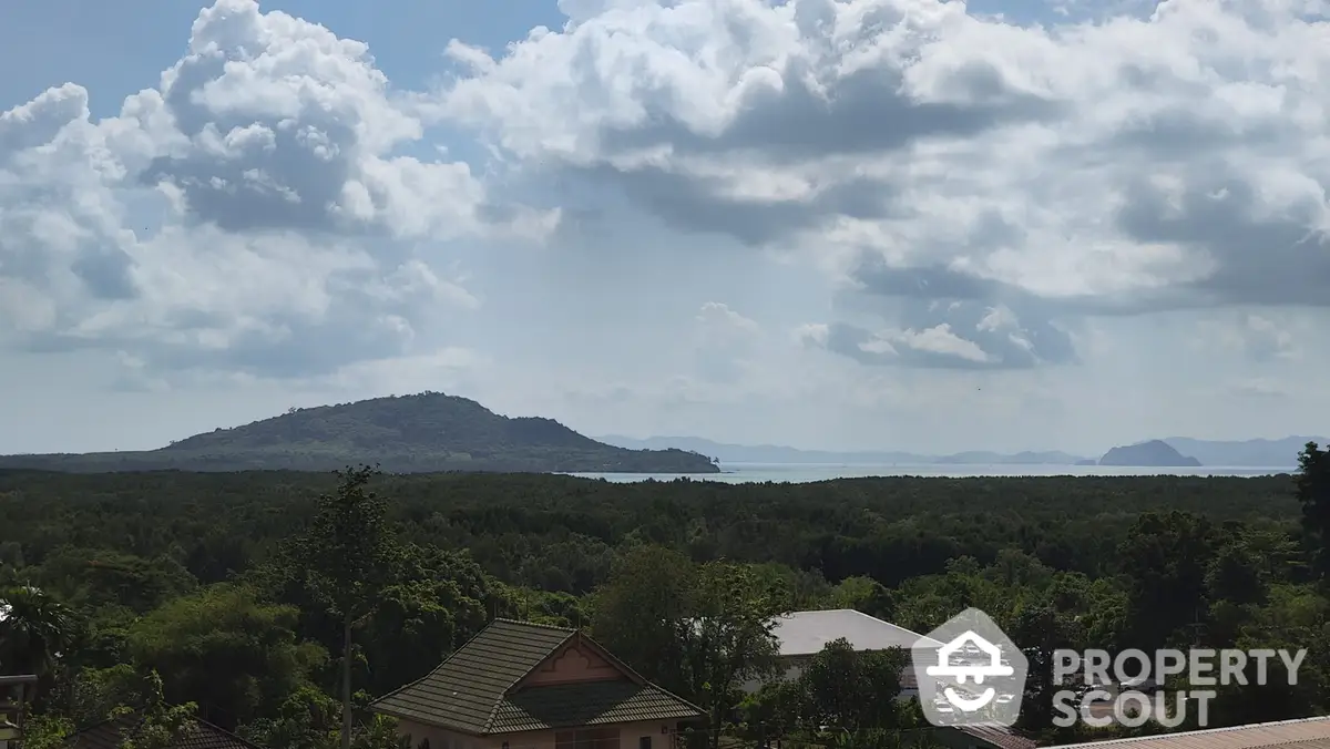 Breathtaking panoramic view from a luxurious property, showcasing lush greenery, distant mountains, and a serene water body, ideal for high-end living.