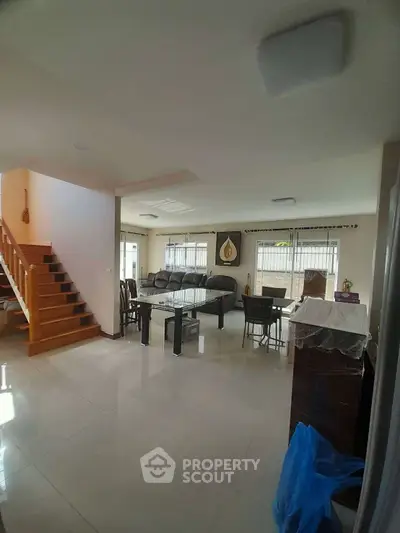 Spacious living room with modern decor and staircase, ideal for family gatherings.