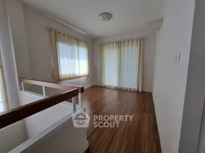 Spacious room with wooden flooring and large windows, perfect for a bright and airy living space.
