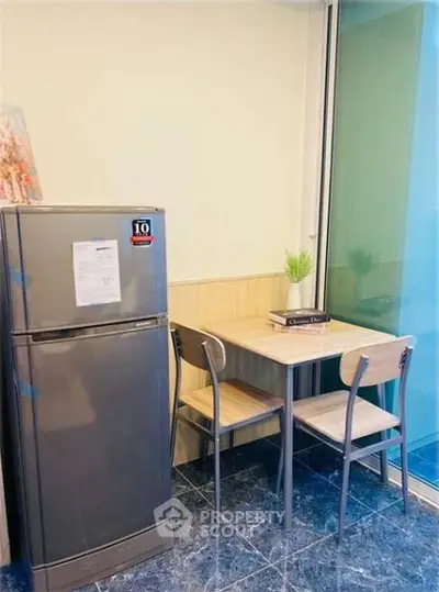Cozy kitchen corner with fridge and dining table in modern apartment