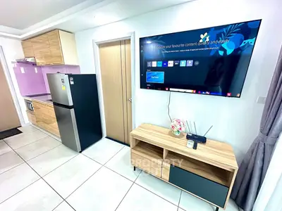 Modern living room with sleek TV, stylish wooden furniture, and contemporary kitchen appliances.