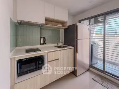 Modern kitchen with sleek appliances and open layout, featuring a fridge, oven, and stylish cabinetry.