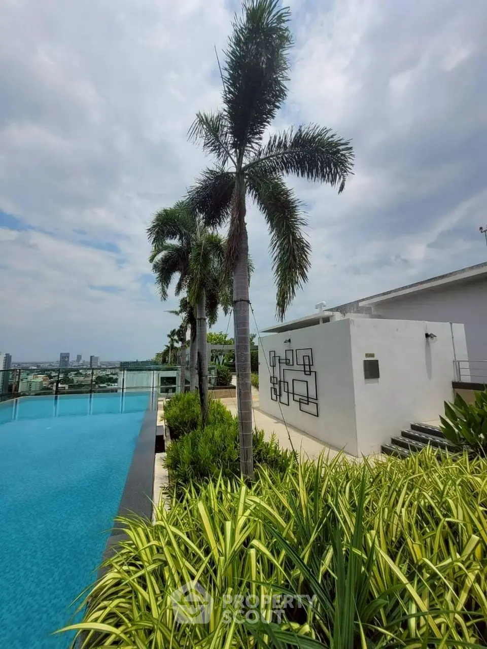 Luxurious rooftop pool with stunning city view and lush greenery