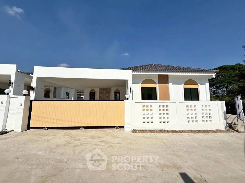 Modern single-story house with a spacious driveway and contemporary design.
