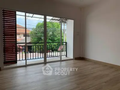 Spacious room with large windows and balcony view, perfect for natural light lovers.