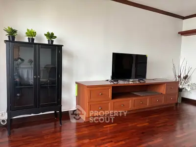 Spacious living room with elegant wooden flooring and modern TV setup