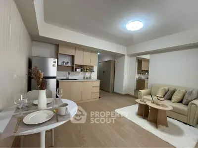 Modern open-layout living room and kitchen with stylish decor and cozy ambiance.