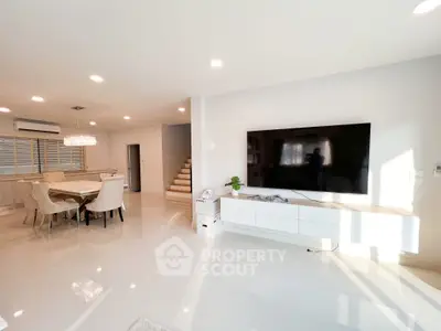 Spacious modern living room with large TV and elegant dining area