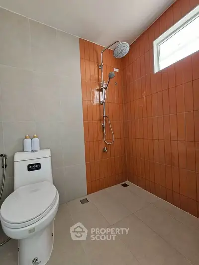 Modern bathroom with sleek shower and stylish orange tiles