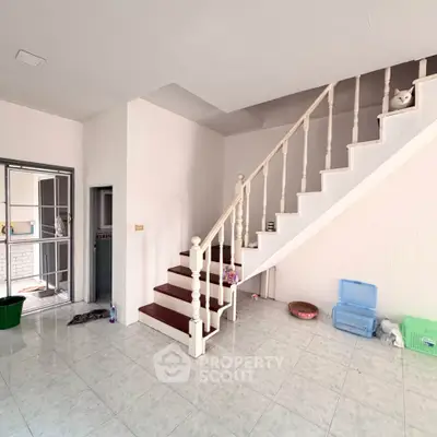 Spacious interior with elegant staircase and tiled flooring in modern home