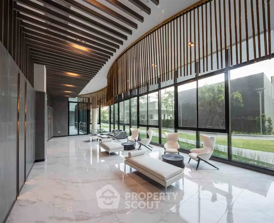 Luxurious modern lobby with sleek design and floor-to-ceiling windows offering serene garden views.