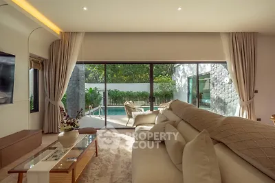 Luxurious living room with pool view, elegant decor, and abundant natural light in a modern home.