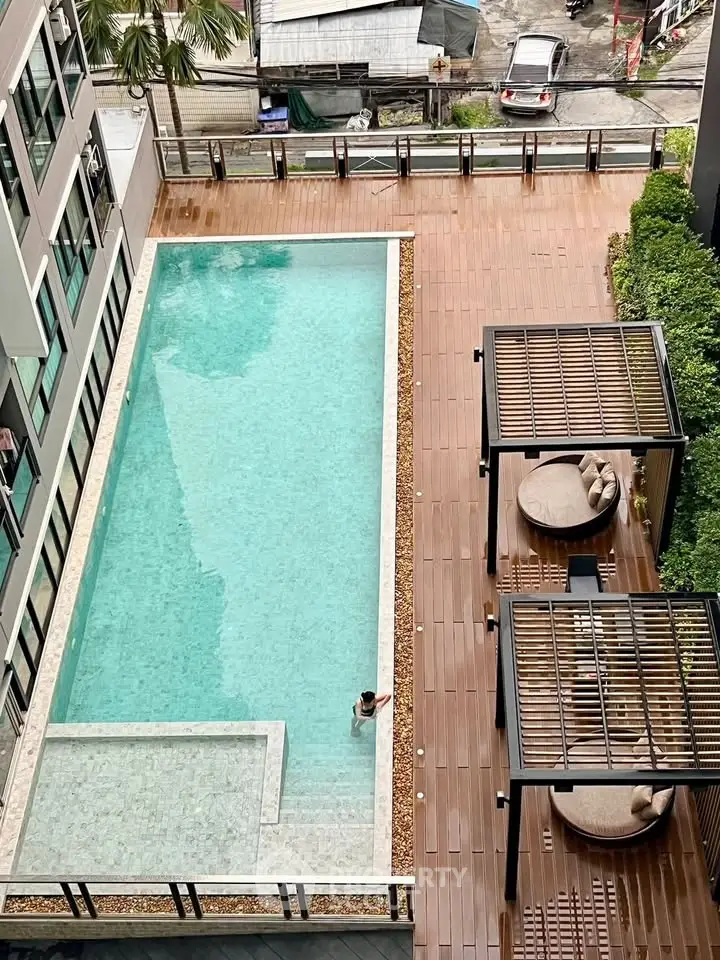 Luxurious apartment complex with a stunning rooftop pool and stylish lounging area.