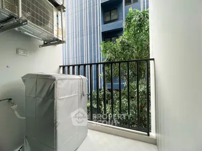 Modern balcony with air conditioning unit and lush greenery view in urban setting.