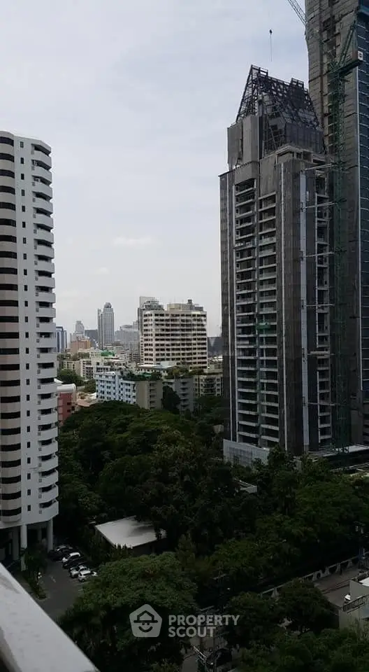 Stunning urban skyline view from a high-rise balcony, showcasing modern architecture and lush greenery.