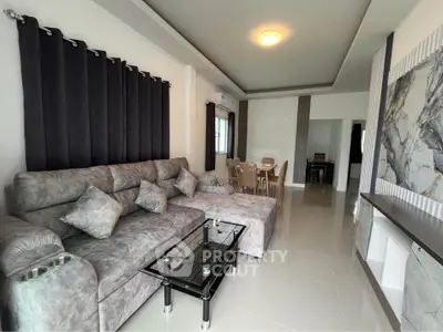 Spacious modern living room with elegant gray sofa and glass coffee table