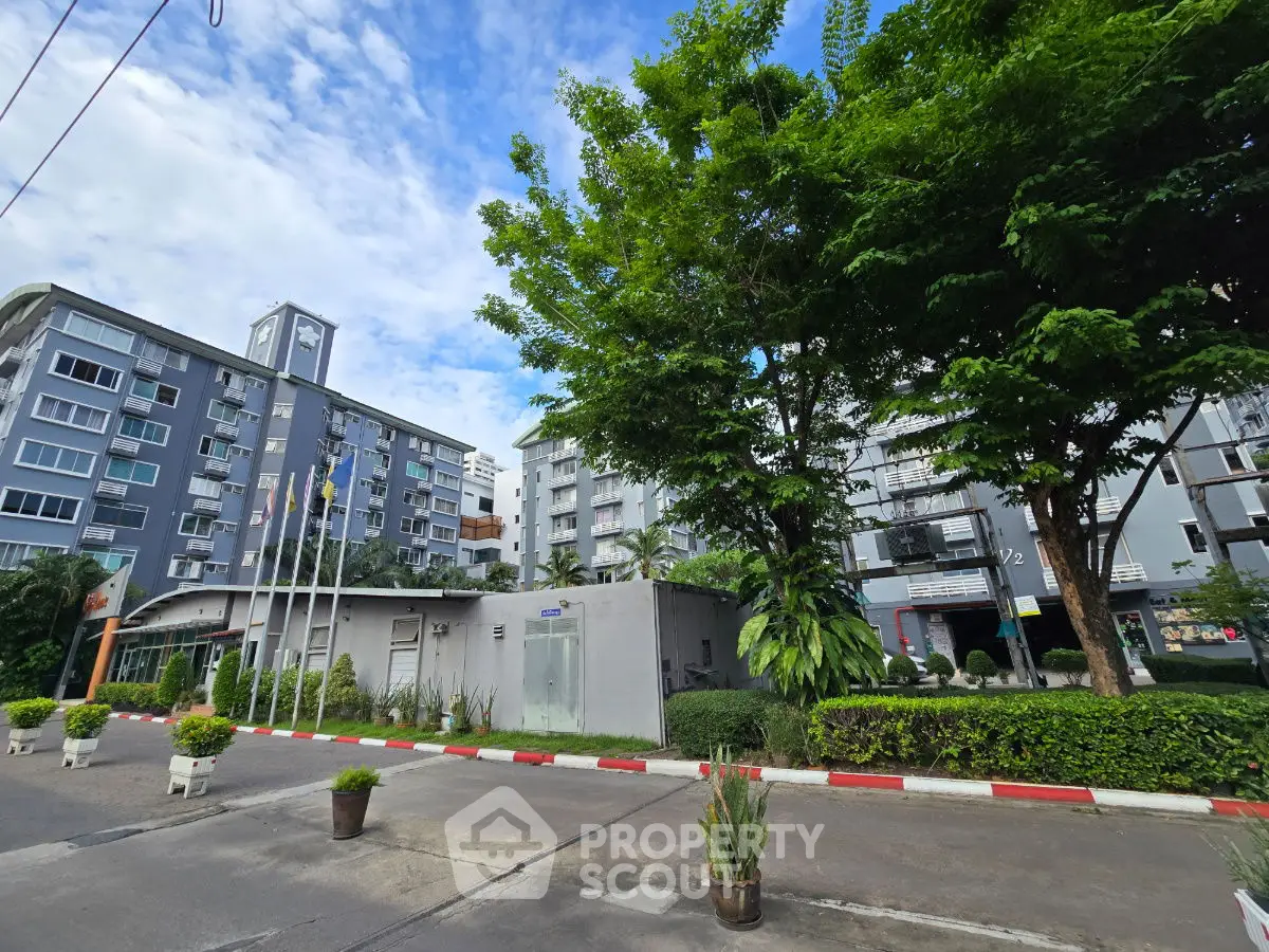 Modern apartment complex with lush greenery and clear blue sky