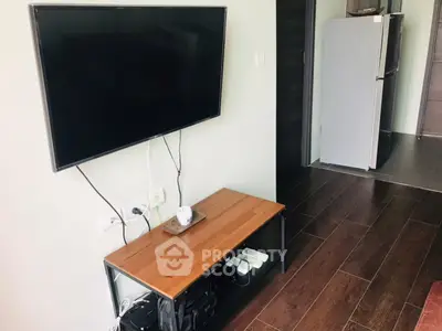 Modern living room with wall-mounted TV and sleek wooden flooring