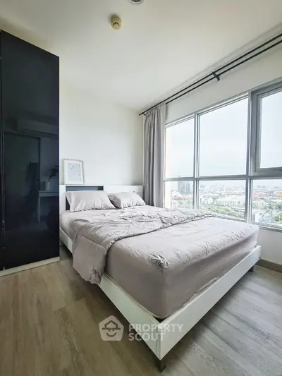 Modern bedroom with large windows offering stunning city views