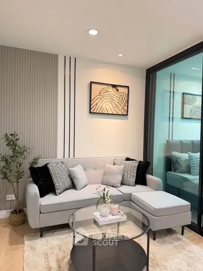 Stylish modern living room with cozy sofa, chic decor, and glass coffee table in a contemporary apartment.
