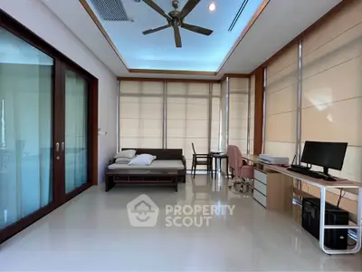 Spacious study room with modern desk, computer setup, and comfortable seating, ideal for productivity and relaxation.