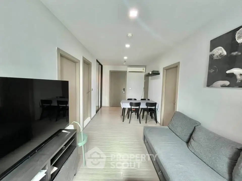 Modern living room with sleek furniture and dining area in a stylish apartment.