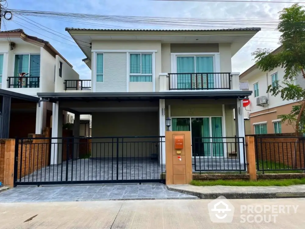 Charming two-story home with spacious balcony and secure carport, nestled in a serene neighborhood, boasting modern design and lush greenery.