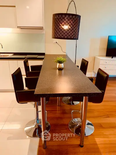 Modern kitchen with sleek black countertop and stylish bar stools