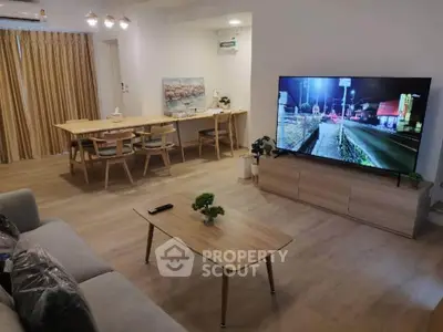 Spacious modern living room with large TV and elegant dining area, perfect for entertaining.