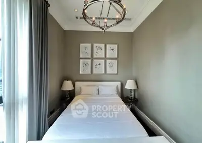 Elegant bedroom with modern chandelier and framed art, featuring a cozy bed and stylish lamps.