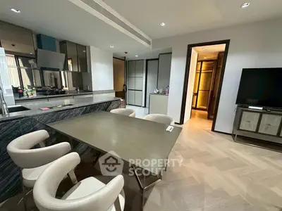 Modern open-layout kitchen and dining area with sleek design and contemporary furniture.