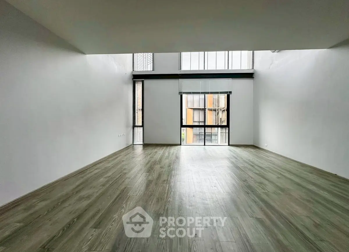 Spacious modern living room with high ceilings and large windows.