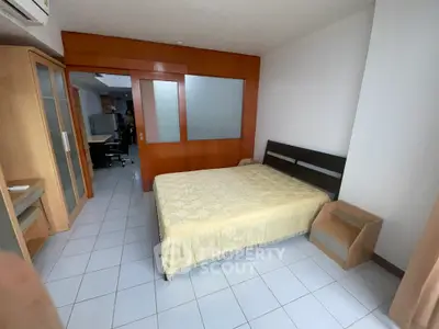 Spacious bedroom with wooden accents and adjacent study area