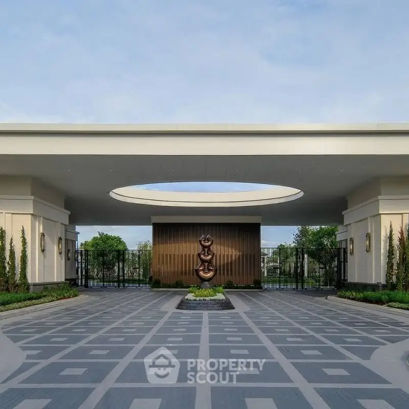 Elegant entrance with modern sculpture and landscaped surroundings