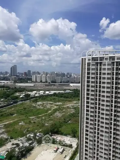 Stunning cityscape view from high-rise building with lush greenery and urban skyline.