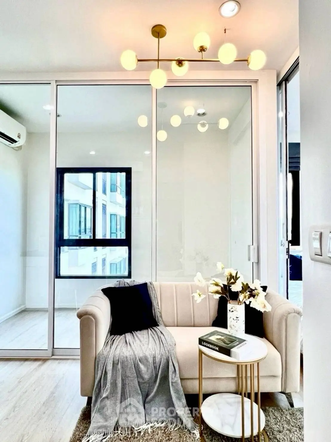 Modern living room with elegant chandelier and cozy sofa in bright apartment