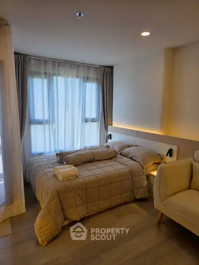 Cozy bedroom with modern decor and large windows offering natural light