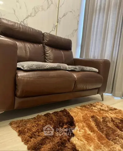Luxurious living room with elegant brown leather sofa and plush rug