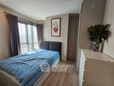Modern bedroom with stylish decor and large window offering natural light