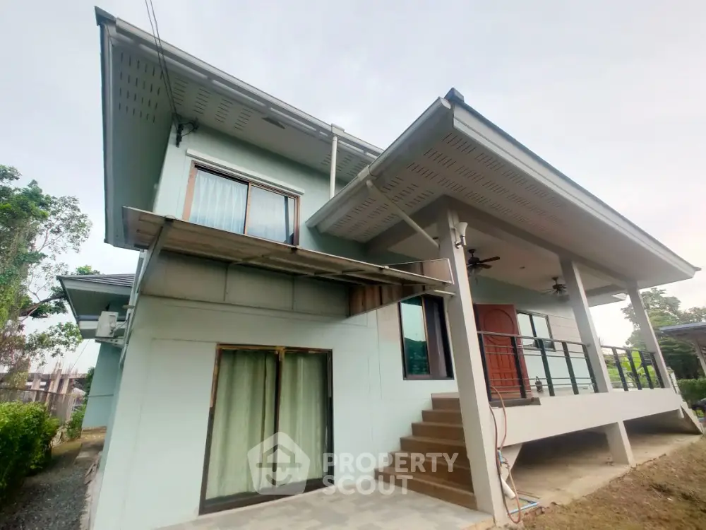 Modern two-story house with elevated entrance and spacious balcony