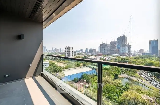 Stunning cityscape view from modern balcony with glass railing and urban skyline.