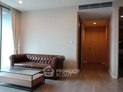 Modern living room with leather sofa and glass coffee table in a stylish apartment.