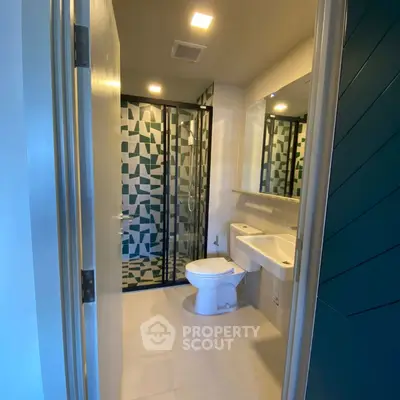 Modern bathroom with geometric shower tiles and sleek fixtures